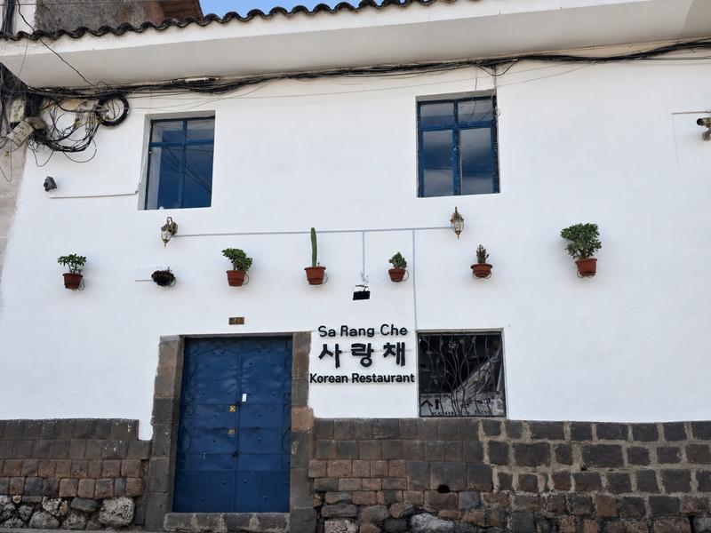 팜파 델 카스티요 거리의 사랑채 간판과 파란 대문